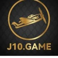 Gold airplane logo in a circle with a dark background, above the text "J10.GAME" in matching gold. The tone is sleek and modern.
